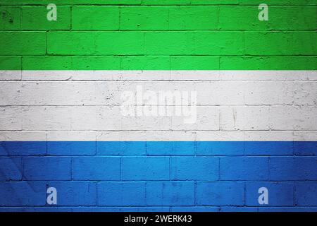 Die Flagge von Sierra Leone ist auf einer Ziegelwand gemalt. Stockfoto