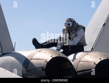 PACIFIC OCEAN (24. Januar 2024) Charles Curry, 1. Klasse der U.S. Navy Aviation Electronics Technician, aus Kansas City, Kan., führt Wartungsarbeiten an einer F/A-18E Super Hornet durch, die den „Black Knights“ der Strike Fighter Squadron (VFA) 154 zugewiesen wurde, auf dem Flugdeck des Flugzeugträgers USS Theodore Roosevelt (CVN 71), Januar 2024. Theodore Roosevelt, Flaggschiff der Carrier Strike Group Nine, führt im Einsatzgebiet der 7. US-Flotte Routineoperationen durch. Als integraler Bestandteil der US-Pazifikflotte betreibt die 7. Flotte die Marine im Indo-Pazifik und stellt die zur Verfügung Stockfoto