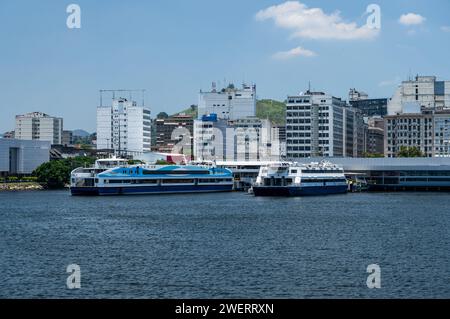 Fährschiffe legten am Fährhafen Arariboia im Bezirk Niteroi Centro an, wie sie von den Gewässern der Bucht Guanabara unter dem blauen Himmel am Sommernachmittag gesehen wurden. Stockfoto