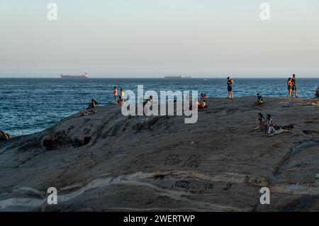 Menschen genießen die Umgebung auf der Felsenhalbinsel Pedra do Arpoador zwischen den Bezirken Ipanema und Copacabana unter dem Sommernachmittag klaren blauen Himmel. Stockfoto