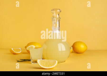 Schuss und Flasche leckeres Limoncello auf beigefarbenem Hintergrund Stockfoto