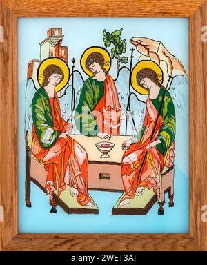 Ikone auf Glas im naiven orthodoxen Stil Osteuropas mit Darstellung der Heiligen Dreifaltigkeit. Gerahmtes Symbol. Stockfoto