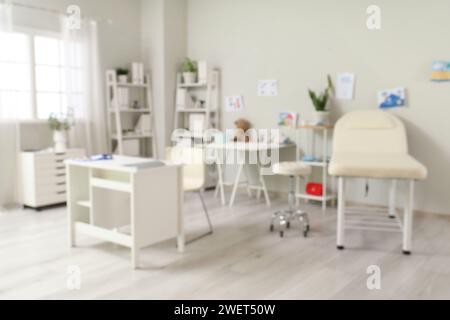 Verschwommenes Bild der Kinderarztpraxis mit Tisch, Sofa und Kinderzeichnungen Stockfoto