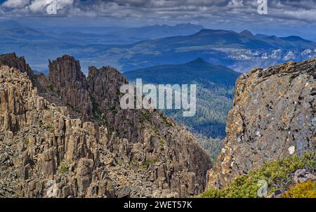 Zerklüftete dolerite Klippen und Säulen in Sonne und Schatten mit Blick auf den fernen Wald am Mount Field West, Mount Field National Park, Tasmanien, Australien Stockfoto
