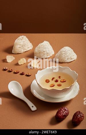 Schüsselsuppe, rohes Vogelnest, Steinzucker und Jujube auf braunem Hintergrund. Gesundheitswesen Lebensmittel, beliebt in Vietnam, China und Südostasien. Werbefot Stockfoto