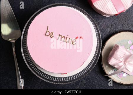 Stehen Sie mit rosa bento-Kuchen und Geschenkboxen auf schwarzem Grunge-Hintergrund. Valentinstag-Feier Stockfoto