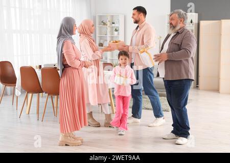 Fröhliche muslimische Familie grüßt einander mit Geschenken zu Hause. Ramadan-Feier Stockfoto