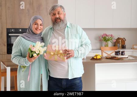 Reifes muslimisches Paar mit Geschenken in der Küche. Ramadan-Feier Stockfoto