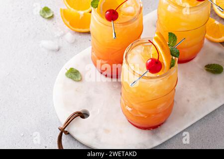 Hurrikan-Cocktail in Tiki-Gläsern, tropischer Cocktail auf Rum-Basis mit Orangen- und Kirschgarnituren Stockfoto