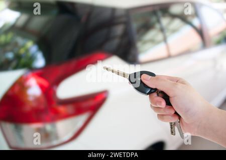 Frauen drücken die Hand auf die ferngesteuerten Alarmanlagen des Autos Stockfoto