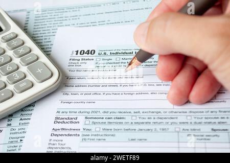 Steuerformular mit Steuerformular und Rechnerhintergrund ausfüllen. Besteuerung und Selbsteinschätzungskonzept. Stockfoto