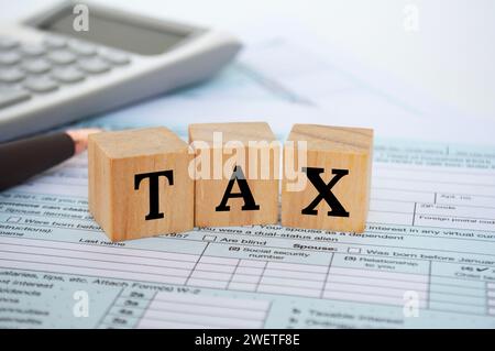 Steuerworte auf Holzwürfeln mit Steuerform und Rechnerhintergrund. Steuerkonzept. Stockfoto