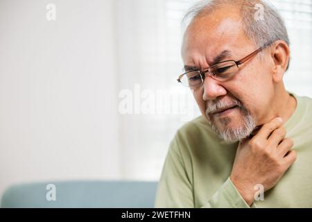 Seniorenmann im Ruhestand, der Schmerzen spürt, Hände, die den Hals halten, und Reizungen im Hals Stockfoto