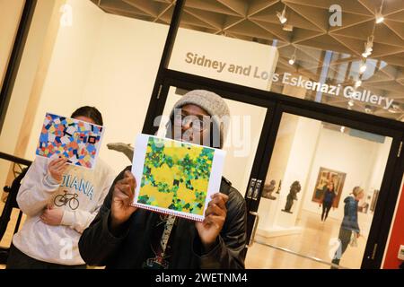 Bloomington, Usa. Januar 2024. Demonstranten halten Bilder von Gemälden vor dem Sidney and Lois Eskenazi Museum of Art: Indiana University, um gegen die Absage einer bevorstehenden Ausstellung für die palästinensische Künstlerin Samia Halaby am 26. Januar 2024 in Bloomington, Indiana, zu protestieren. Halaby, 87 Jahre alt, hat sich für ihre Unterstützung der Palästinenser ausgesprochen. (Foto: Jeremy Hogan/SOPA Images/SIPA USA) Credit: SIPA USA/Alamy Live News Stockfoto