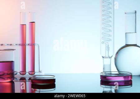 Vorderansicht der Laborglaswaren gefüllt mit bunter Flüssigkeit auf hellem Hintergrund. Leeres Leerzeichen für Produkt und Text anzeigen. Wissenschaftliche Laborforschung und Entwicklung Stockfoto