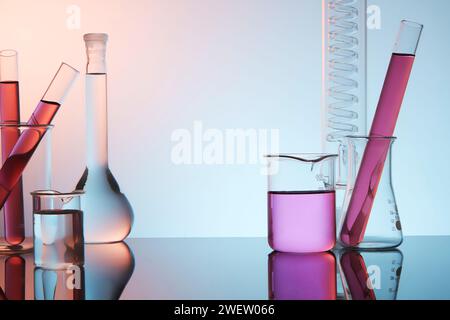 Vorderansicht der Laborausrüstung - Reagenzglas, Becher und Siedekolben gefüllt mit violetter Flüssigkeit, auf violettem Farbverlauf. Konzept: Forschung, Bioch Stockfoto