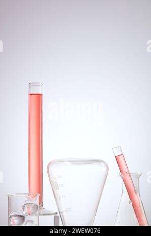 Laborkonzept mit Laborglas mit rosafarbener Flüssigkeit auf hellem Hintergrund. Laborthema. Wissenschaft und medizinischer Hintergrund, Vorderansicht. Stockfoto