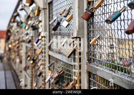 Eine Reihe von Vorhängeschlössern unterschiedlicher Größe am Brückengeländer Stockfoto