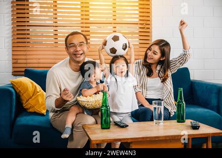 Eine glückliche Familie genießt den Nervenkitzel eines Fußballspiels zu Hause Stockfoto