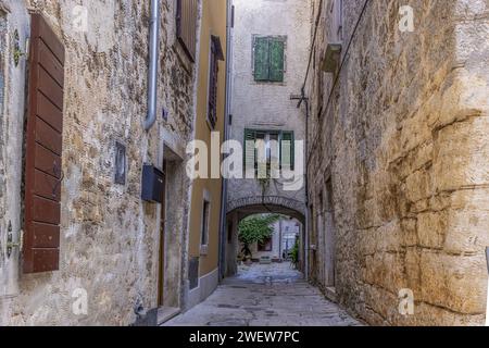 Bild einer typischen Straßenszene aus der historischen kroatischen Stadt Voznjan mit Kopfsteinpflasterstraßen und alten Gebäuden im Morgenlicht Stockfoto