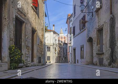 Bild einer typischen Straßenszene aus der historischen kroatischen Stadt Voznjan mit Kopfsteinpflasterstraßen und alten Gebäuden im Morgenlicht Stockfoto