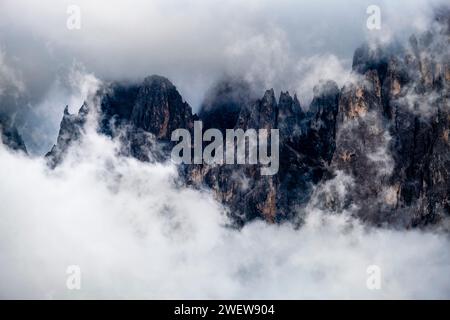 Aufsteigende Wolken nach einem Regenschauer um die Felsklippen rund um die Gipfel der Grohmannspitze und der Fünffingerspitze, von der Seiser Alm aus gesehen. Stockfoto