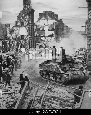 Panzer passieren die Ruinen der normannischen Stadt Flers am 17. August 1944, Teil der alliierten Invasion Europas während des Zweiten Weltkriegs. Stockfoto