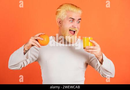 Lustig aufgeregt Mann trinken den Orangensaft. Stockfoto