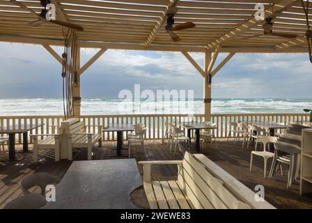 Holztische mit Bänken und einem Baldachin am Meer in Haifa Stockfoto