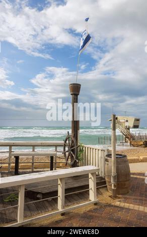 Säule mit einem hölzernen Schiffsrad und der israelischen Flagge auf See bei stürmischem Wetter Stockfoto