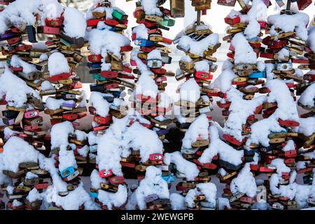 Schneebedeckte Liebesvorhängeschlösser auf der Hohenzollernbahnbrücke über den Rhein, Köln, Deutschland. Januar. 2024 schneebedeckte Liebesschloesser an Stockfoto