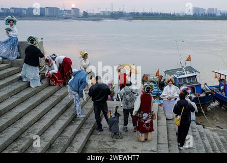 (240127) -- QUANZHOU, 27. Januar 2024 (Xinhua) -- Touristen mit blumigen Kopfbedeckungen posieren für Fotos im Dorf Xunpu der Stadt Quanzhou, südöstlich Chinas Provinz Fujian, 26. Januar 2024. Die blumigen Kopfbedeckungen von Xunpu, auch „Overhead Gardens“ genannt, sind eine Signatur der „Xunpu Women Customs“, die 2008 als nationales immaterielles Erbe gelistet wurde. Anfang 2023 zogen sie Millionen von Augen in der Cyber-Welt an, gefolgt von einem nachhaltigen Touristenboom im Dorf, wo Besucher buchstäblich ihre Köpfe in sie stecken können. Fotoshooting, Essen und andere Gastfreundschaft Dienstleistungen haben die Quelle von i diversifiziert Stockfoto