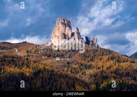 Die Felsformation Cinque Torri und die Berghütte Rifugio Cinque Torri, umgeben von gelben Lärchen und grünen Kiefern bei Sonnenaufgang im Herbst. Stockfoto