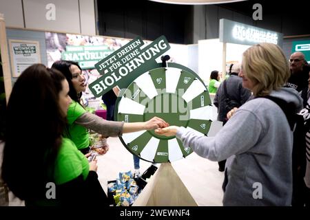 Gruene Woche Berlin DEU, Deutschland, Berlin, 23.01.2024 Besucher und Aussteller von Rewe bei einem Glueckspiel zum Thema oekologische Landwirtschaft in der Biohalle vom Forum Moderne Landwirtschaft auf der Messe der Internationalen Gruenen Woche unter dem Motto Moege die Vielfalt mit Euch sein in Berlin Deutschland. Die Internationale Gruene Woche Berlin ist eine internationale Verbrauchermesse und Ausstellung der Ernaehrungswirtschaft, Landwirtschaft, Gartenbau und für landwirtschaftliche Produkte aus aller Welt. Grüne Woche en: Besucher und Aussteller aus Rewe bei einem Chanc-Spiel Stockfoto