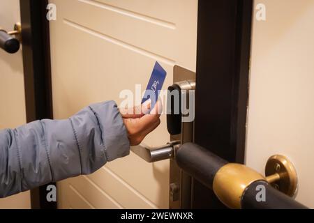 Nahaufnahme einer Hand, die eine Schlüsselkarte hält, um eine Hoteltür zu öffnen Stockfoto
