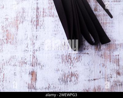 Schwarzer Karategürtel auf rustikalem Holzhintergrund. Stockfoto