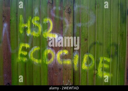 Harefield, Großbritannien. Januar 2024. HS2 Ecocide Graffiti auf einem Zaun in Harefield. In Harefield, London Borough of Hillingdon, werden die Arbeiten an der HS2 High Speed Rail Colne Valley Viaduct fortgesetzt, die neue Hochgeschwindigkeitszüge von London nach Birmingham bringen wird. Obwohl die nördliche Phase 2 von HS2 von Rishi Sunak abgesagt wurde, hat der Bürgermeister von Greater Manchester, Andy Burnham, und der Bürgermeister der West Midlands Andy Street wird nächste Woche den Verkehrsminister Mark Harper treffen, um Pläne für einen Ersatz für die abgebrochene HS2-Strecke zwischen Birmingham und Manche zu besprechen Stockfoto