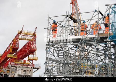 Harefield, Großbritannien. Januar 2024. In Harefield, London Borough of Hillingdon, werden die Arbeiten an der HS2 High Speed Rail Colne Valley Viaduct fortgesetzt, die neue Hochgeschwindigkeitszüge von London nach Birmingham bringen wird. Eine riesige orangene 700-Tonnen-Brückenbaumaschine namens Dominque hebt die riesigen Betondecksegmente, die die Bögen des Viadukts bilden, in Position. Vom 1. Februar bis zum 30. April ist der Fußweg entlang des Canal Grande Union zeitweise gesperrt, während der Viadukt über dem Kanal gebaut wird. Kredit: Maureen McLean/Alamy Stockfoto