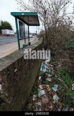 Müll wurde an einer Bushaltestelle in der Wallisdown Road in Bournemouth Dorset entsorgt. An der Bushaltestelle gibt es keinen Abfalleimer, so dass die Gegend schwer ist mit Müll, der von Pendlern weggeworfen wird. Stockfoto