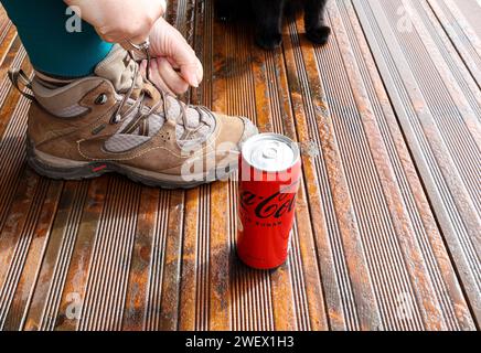 Eine Coca-Cola-Null-Zucker-Dose nahe dem Fuß der Frau Stockfoto