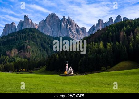 Blick auf die Kapelle von St. John in Ranui in St. Magdalena im Villnösstal im Herbst, Nordwände und Gipfel der Geisgruppe in der Ferne. Bolz Stockfoto