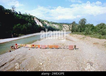 Vrancea County, Rumänien, ca. 1991. Die Einheimischen waschen Wäsche und Teppiche im Fluss Putna mit der Hand, wobei sie an einem Dock der lokalen Regierung den Wasserstand messen und die Teppiche am Kabel trocknen. Stockfoto