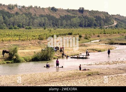 Vrancea County, Rumänien, ca. 1991. Die Einheimischen waschen im Fluss Putna ihre Wäsche. Stockfoto