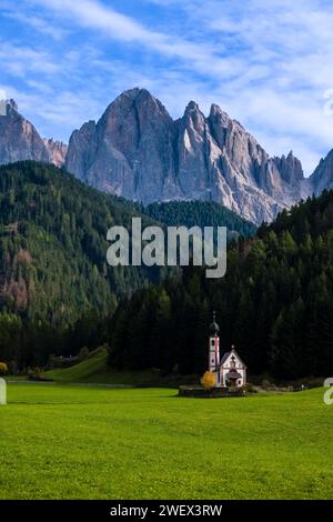 Blick auf die Kapelle von St. John in Ranui in St. Magdalena im Villnösstal im Herbst, Nordwände und Gipfel der Geisgruppe in der Ferne. Bolz Stockfoto