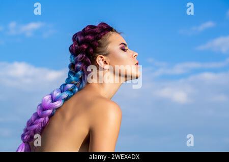 Helles Make-up, rosafarbene Zöpfe, Zöpfe. Mädchen buntes Kanekalon, geflochten in ihren Haaren. Hübsche Frau, buntes violettes Ombre-Haar und Profi Stockfoto