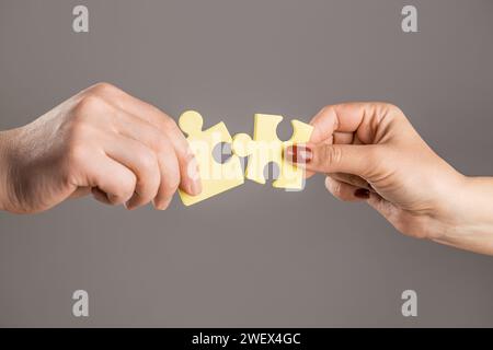 Puzzles. Mann und Frau halten ein Puzzle in der Hand. Geschäftslösungen, Erfolg und Strategiekonzept. Die Hände verbinden Puzzle. Hand des Mannes und Stockfoto