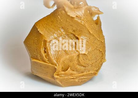 Genießen Sie den cremigen Reichtum der Erdnussbutter, die in exquisiten Details in einer 1:1-Vergrößerung erfasst wird und eine unwiderstehliche Textur und einen gesunden Geschmack offenbart. Stockfoto