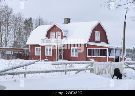 Typisch schwedisches rot lackiertes Bauernhaus in Bredebolet in Skaraborg im Vaestra Goetaland in Schweden im Winter Stockfoto