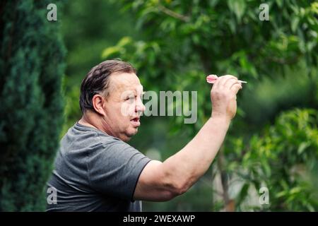 Ein Mann, der ein Spiel Dart spielt. Er braucht Konzentration und Perfektion, um zu gewinnen Stockfoto