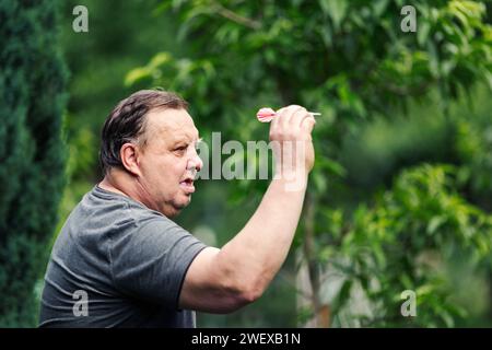 Ein Mann, der ein Spiel Dart spielt. Er braucht Konzentration und Perfektion, um zu gewinnen Stockfoto